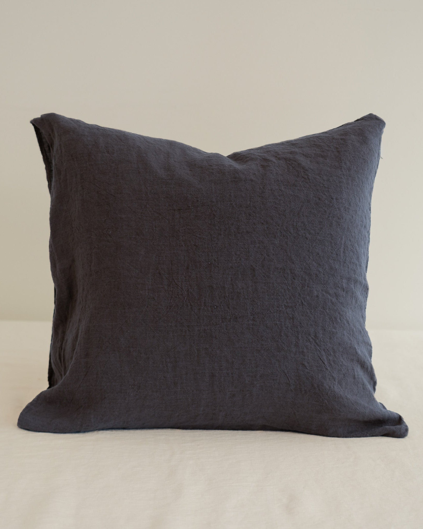 Dark gray pillow on a beige background