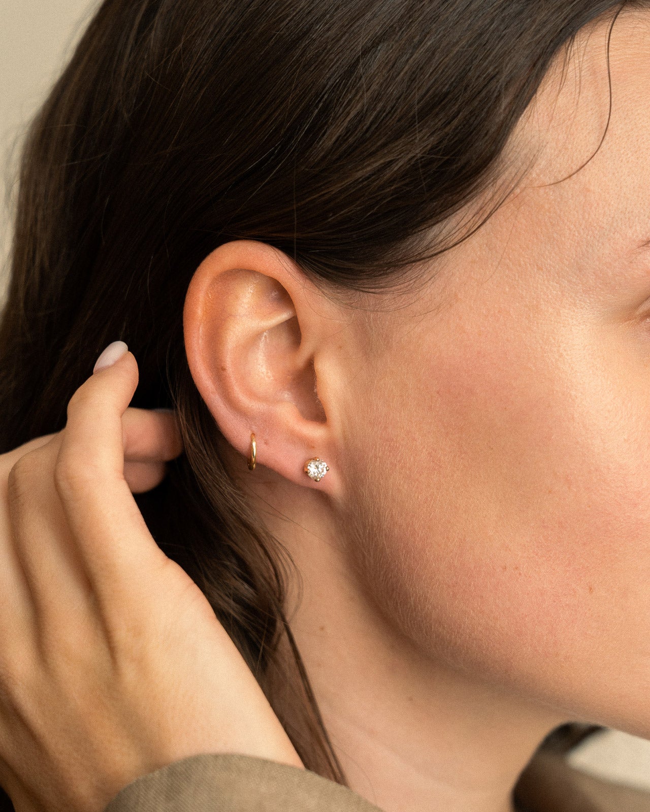 Close-up of a person wearing a diamond earring with a blurred background