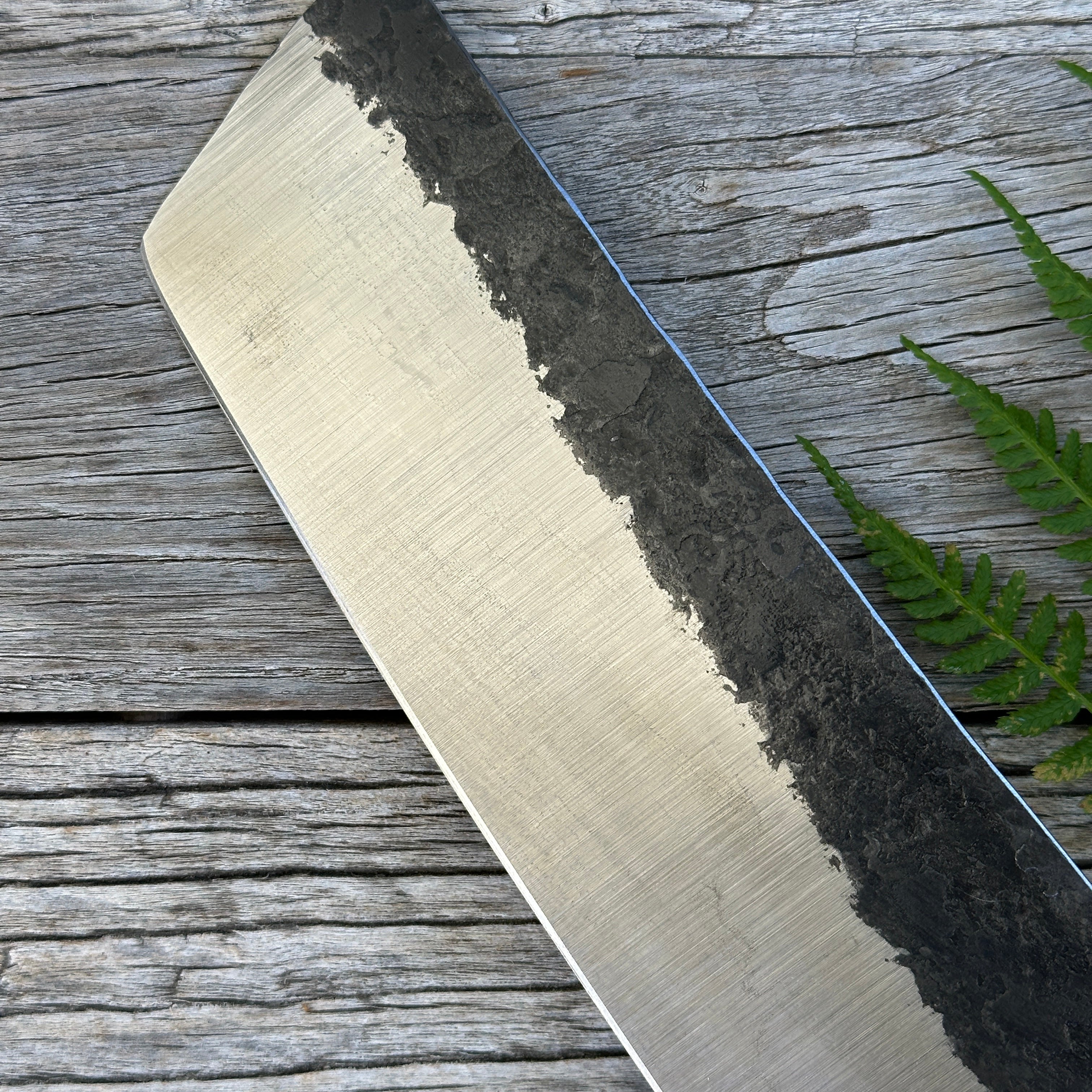 Leechtown Blacksmith Co. for Confluence Nimmo Bay knife blade on a wooden surface