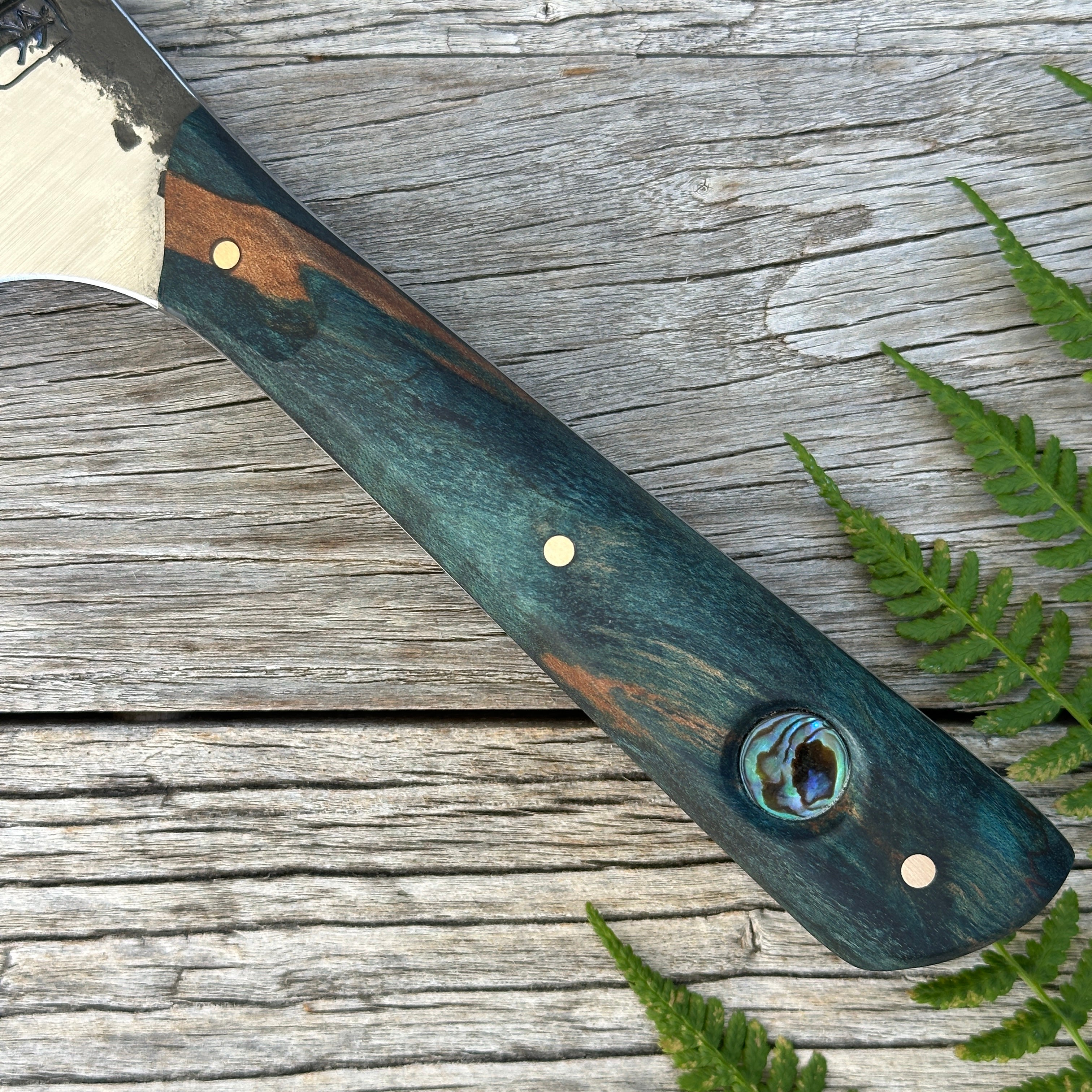 Leechtown Blacksmith Co. for Confluence Nimmo Bay knife with a wooden handle on a wooden surface with ferns