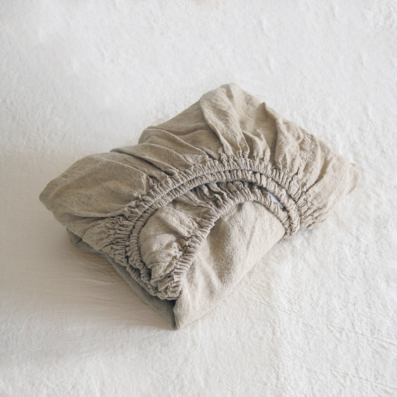 Beige fitted sheet on a white surface