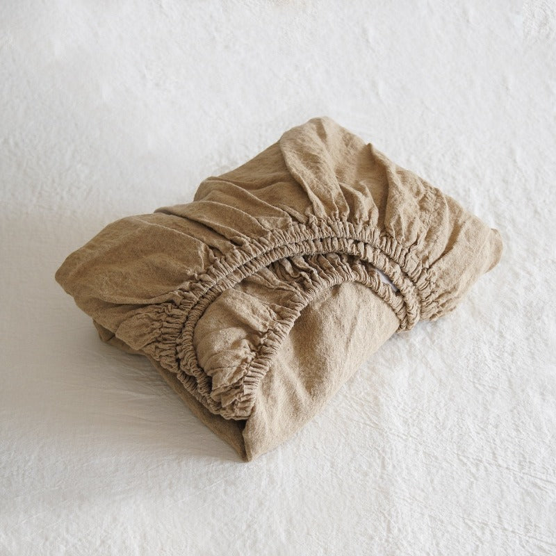 Beige fitted sheet on a white surface