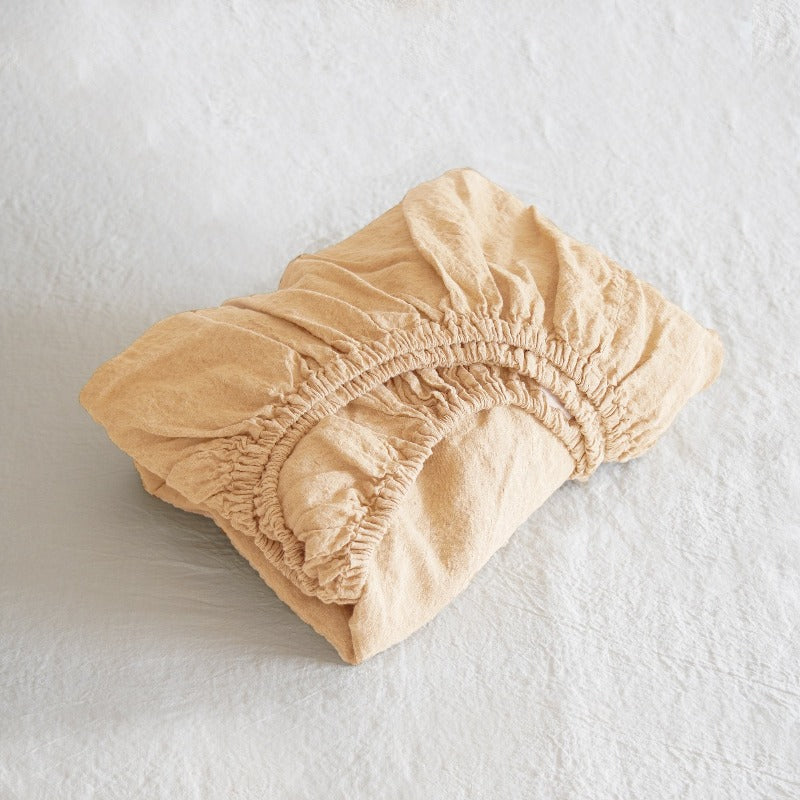 Paach fitted sheet on a textured white background
