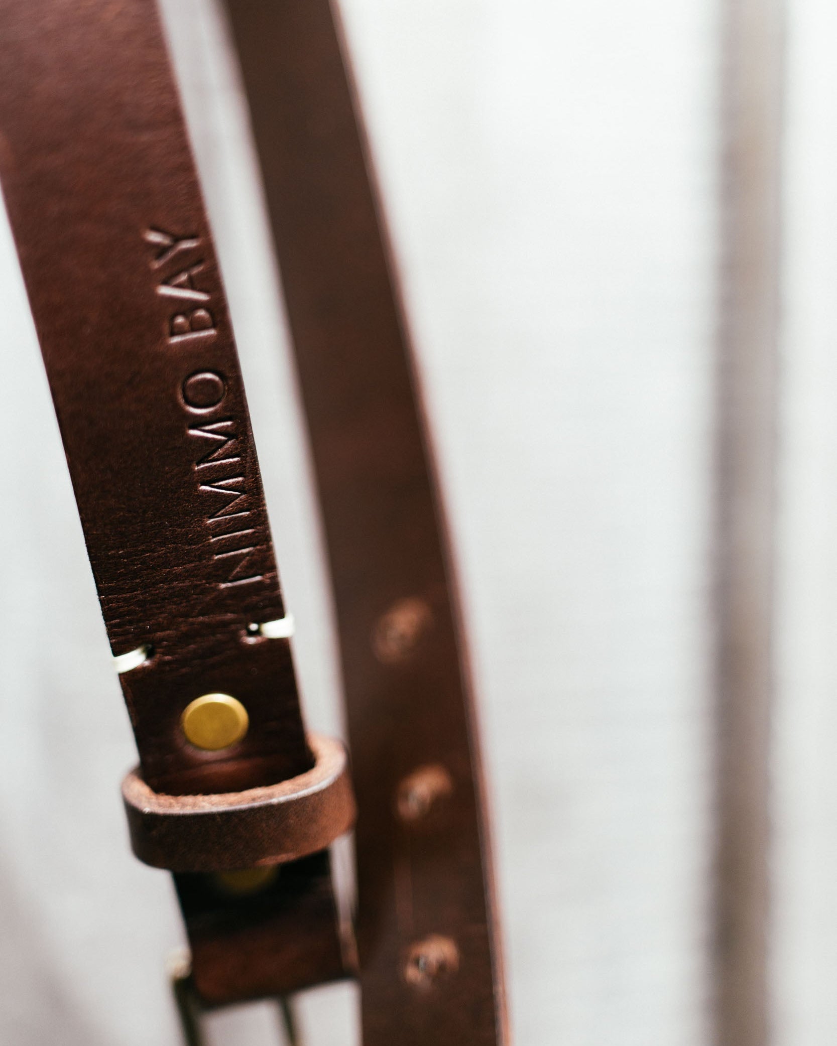Brown leather belt with visible branding on a light background