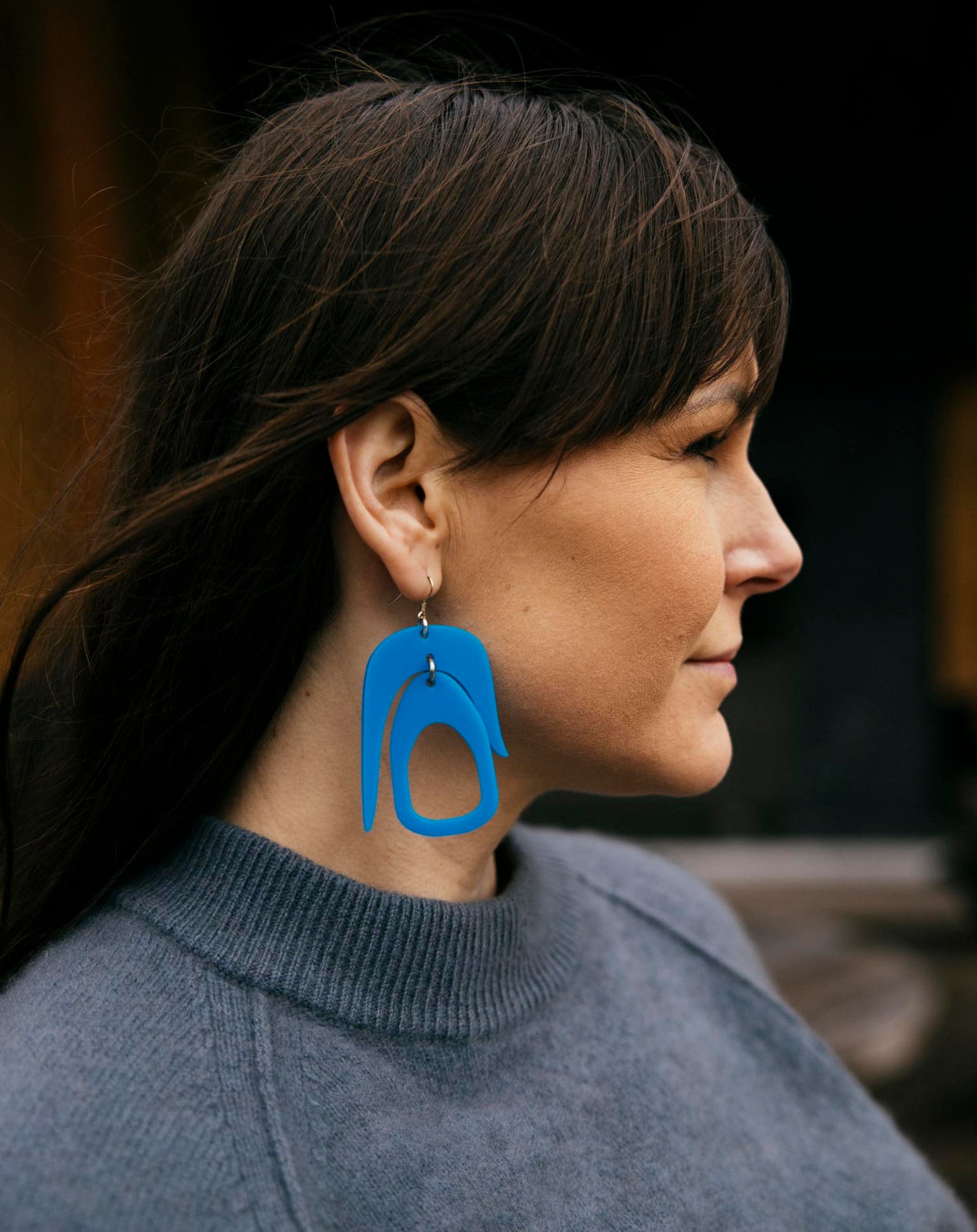 Salish Chandelier Earrings in Blue by warren steven scott on a brunette woman