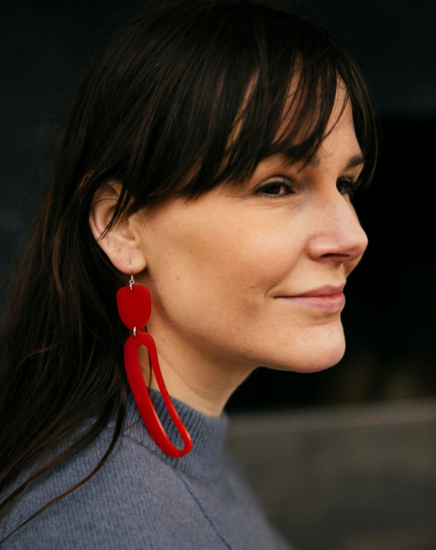 Elongated Ovoid Earrings in Red by Warren Steven Scott worn by a brunette woman