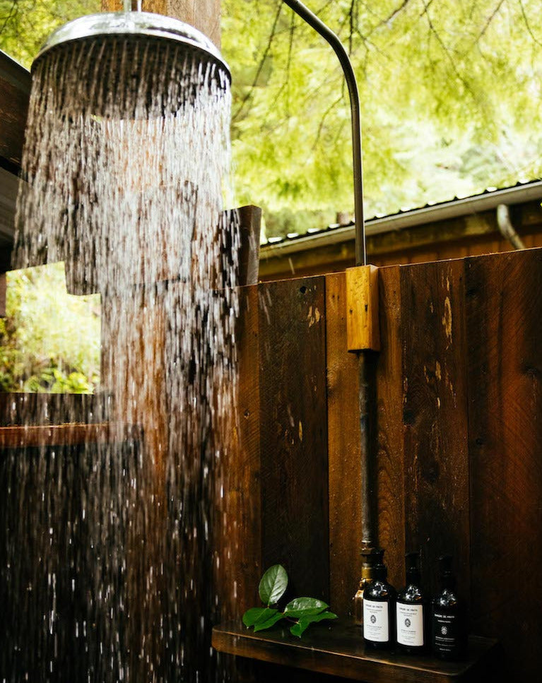 sangre de fruta botanical shampoo and conditioner in an outdoor shower